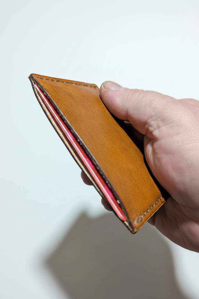 Slim handmade tan leather card sleeve with pink interior