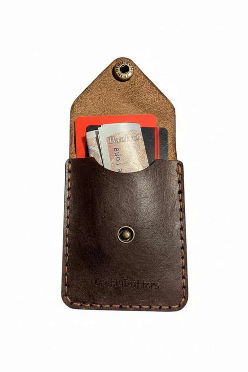 Handmade dark brown leather card holder with cash and cards inside.