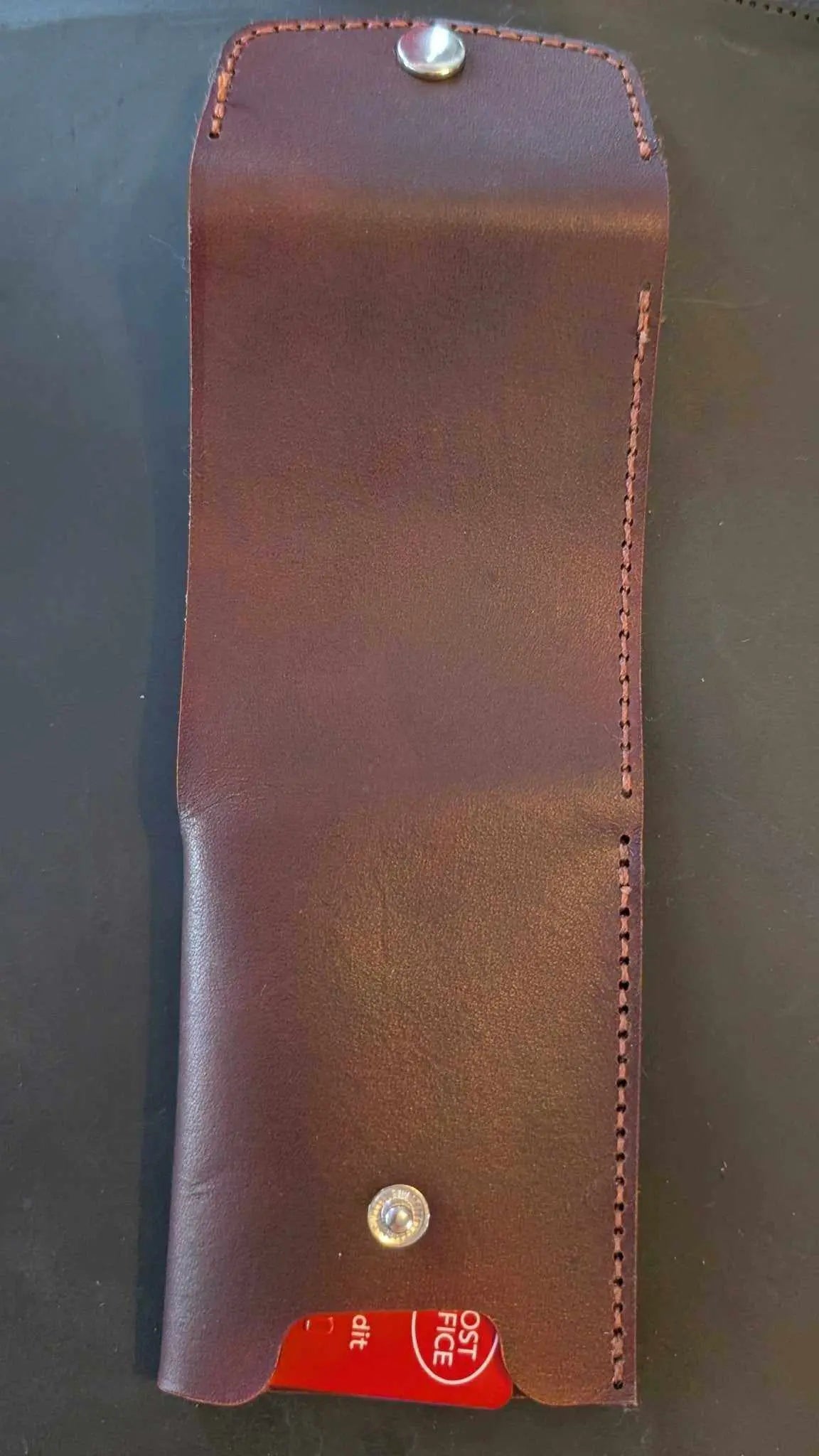 Handmade dark brown leather wallet with metal snap closure.
