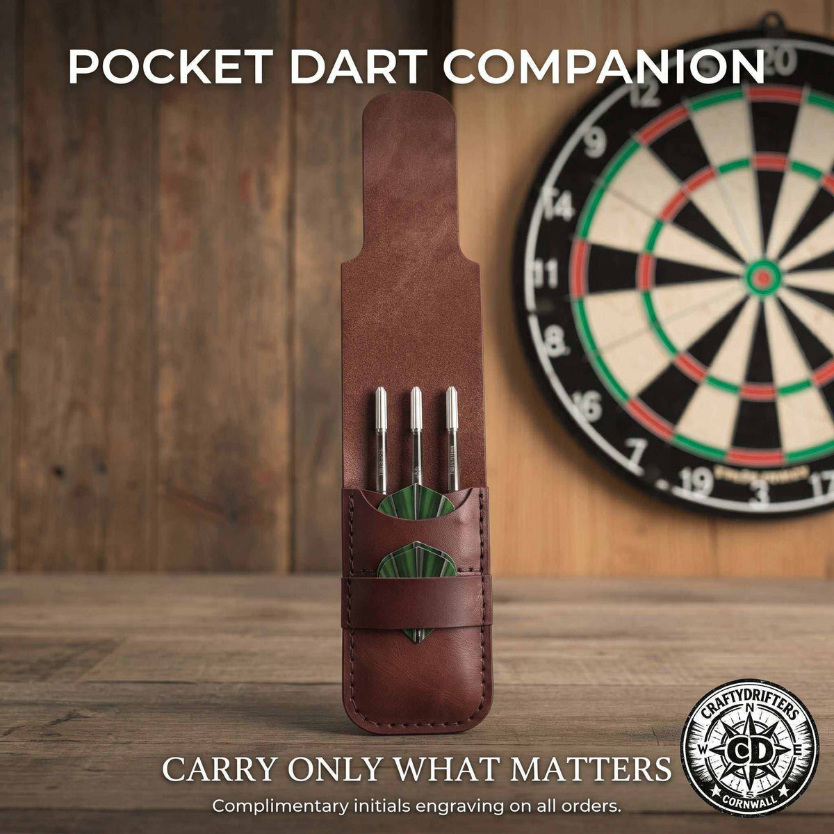 Handmade brown leather dart case holding three silver darts with green flights.