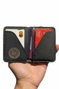 The Devonport black leather bi-fold wallet open in hand with cards inside