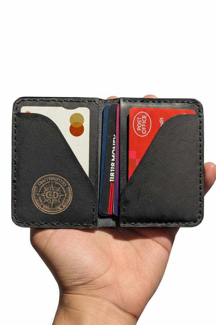 The Devonport black leather bi-fold wallet open in hand with cards inside