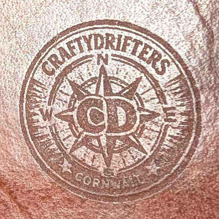 CraftyDrifters Cornwall logo stamped on brown handmade leather.