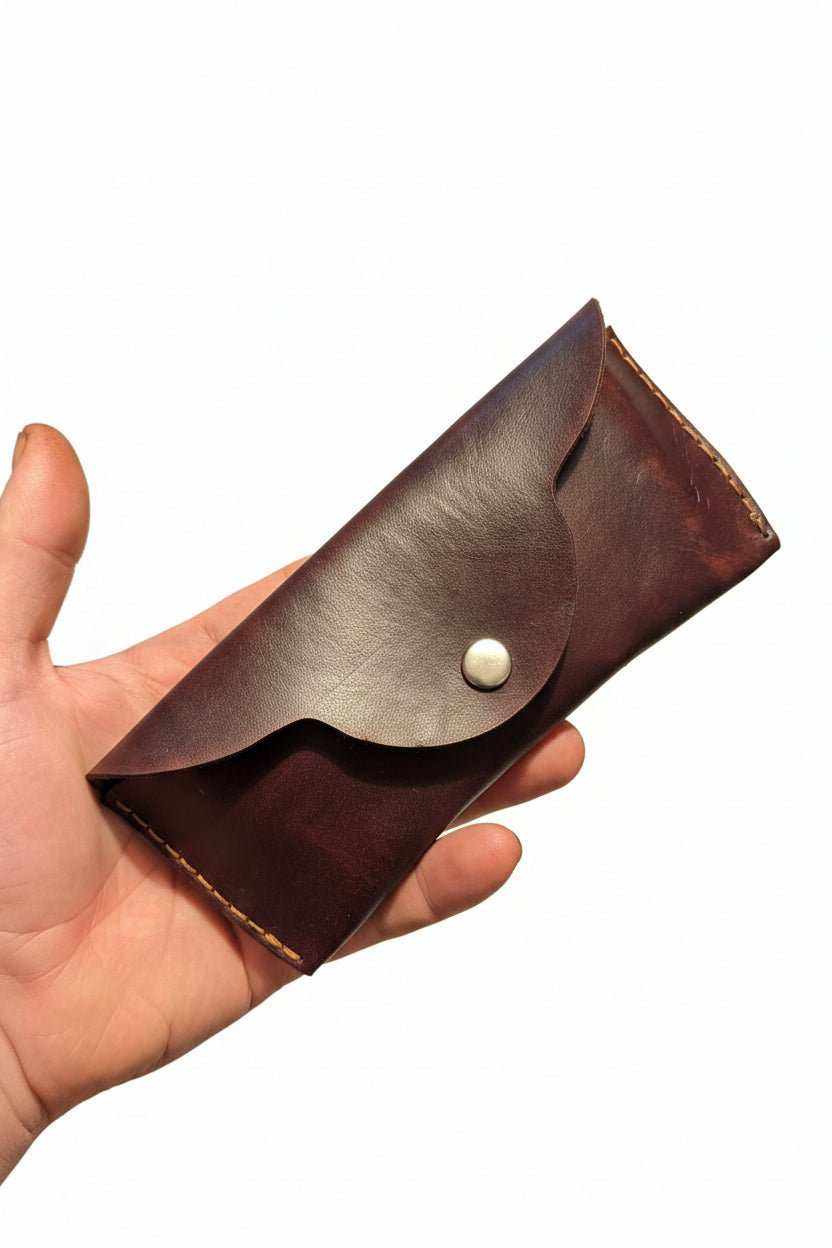Handmade dark brown leather glasses case with a scalloped flap and silver snap closure