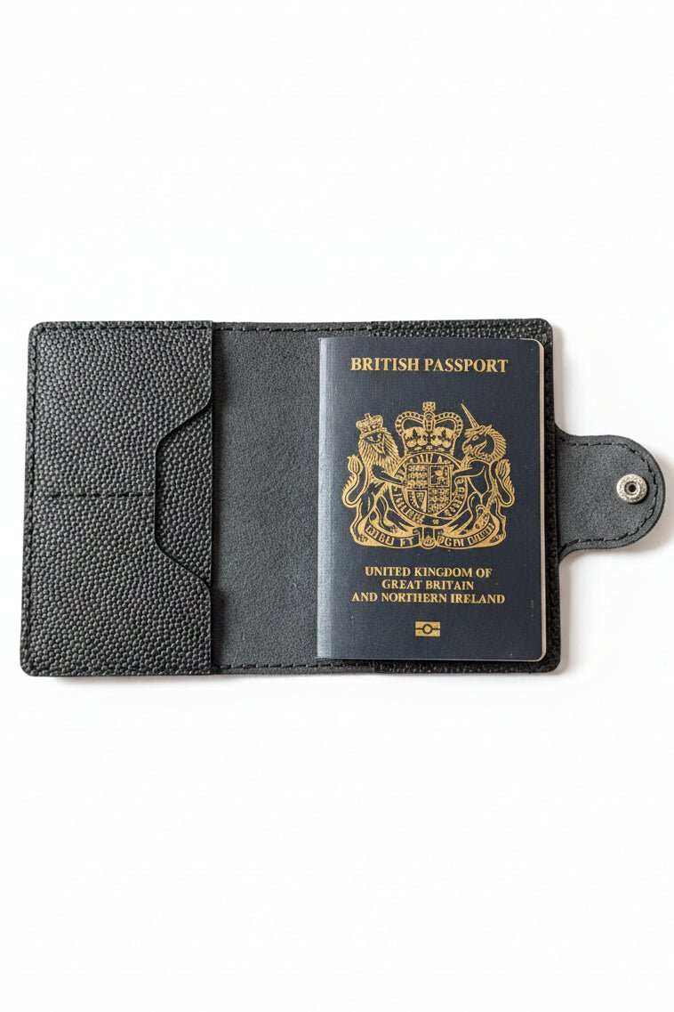 Black handmade leather passport holder with a textured finish on a white background.