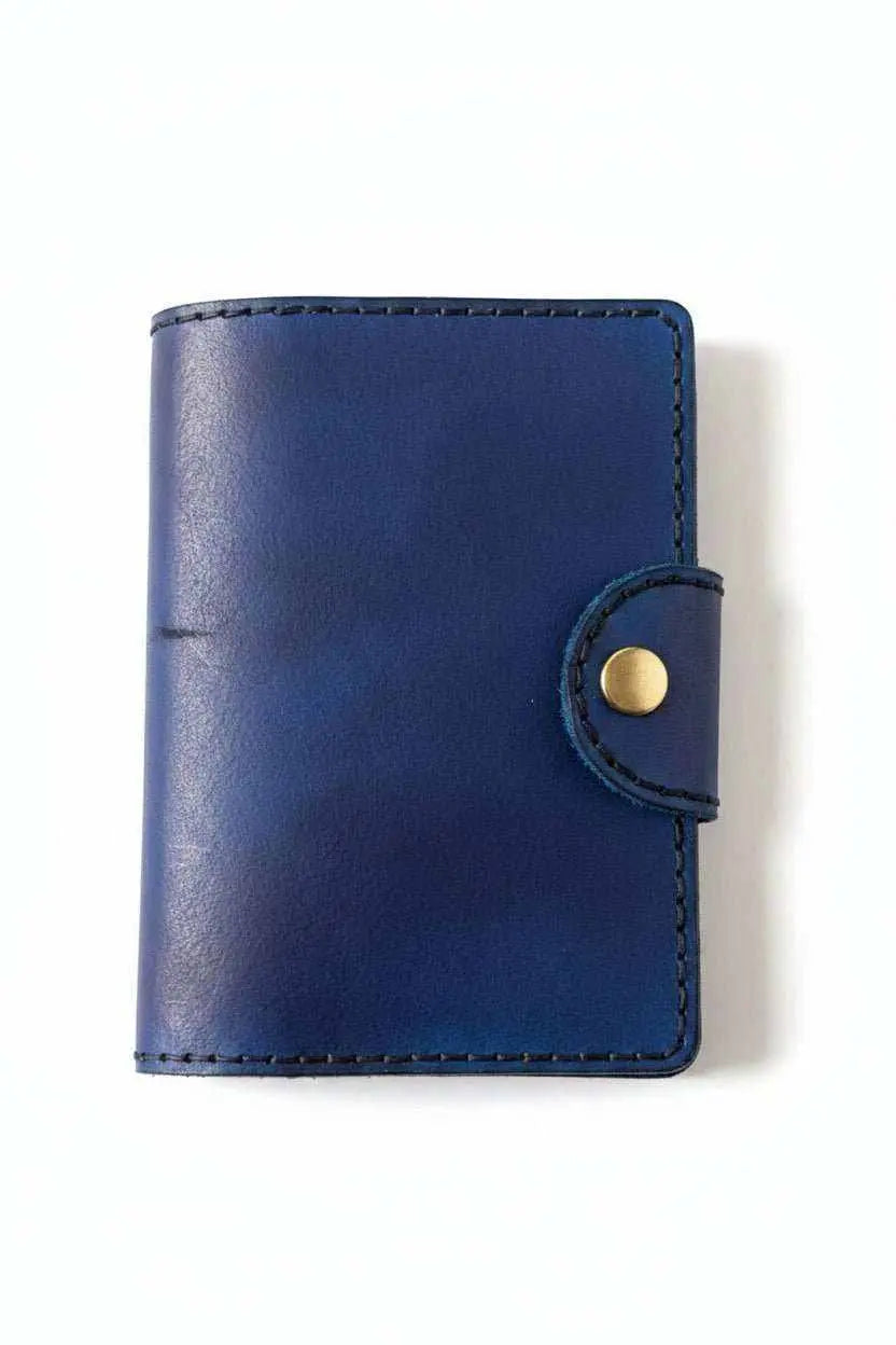 Handmade navy blue leather passport cover with a snap closure and visible stitching