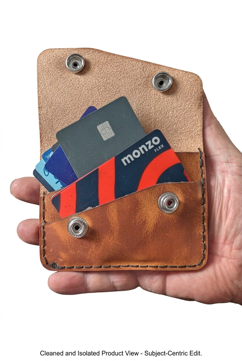 Two-pocket tan leather card and cash purse open with bank cards inside