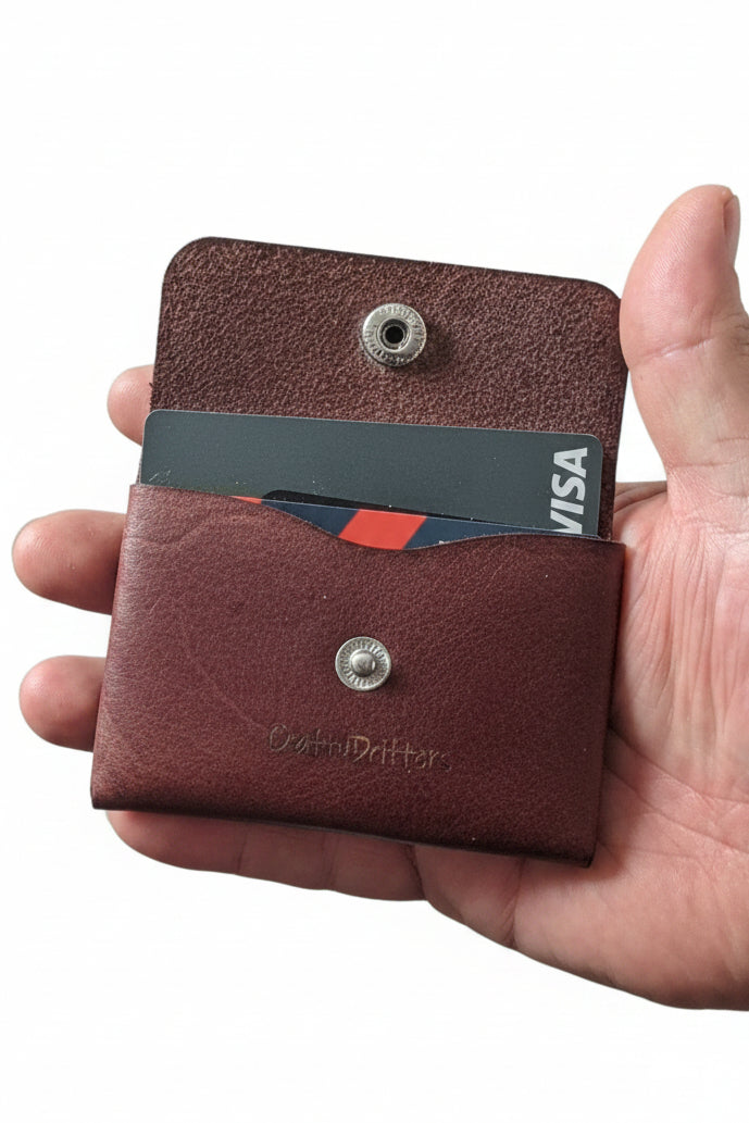Hand holding the open stitch-free leather coin purse with a card inside