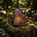 The Woodland Italian pull-up leather wallet closed with a snap, on moss