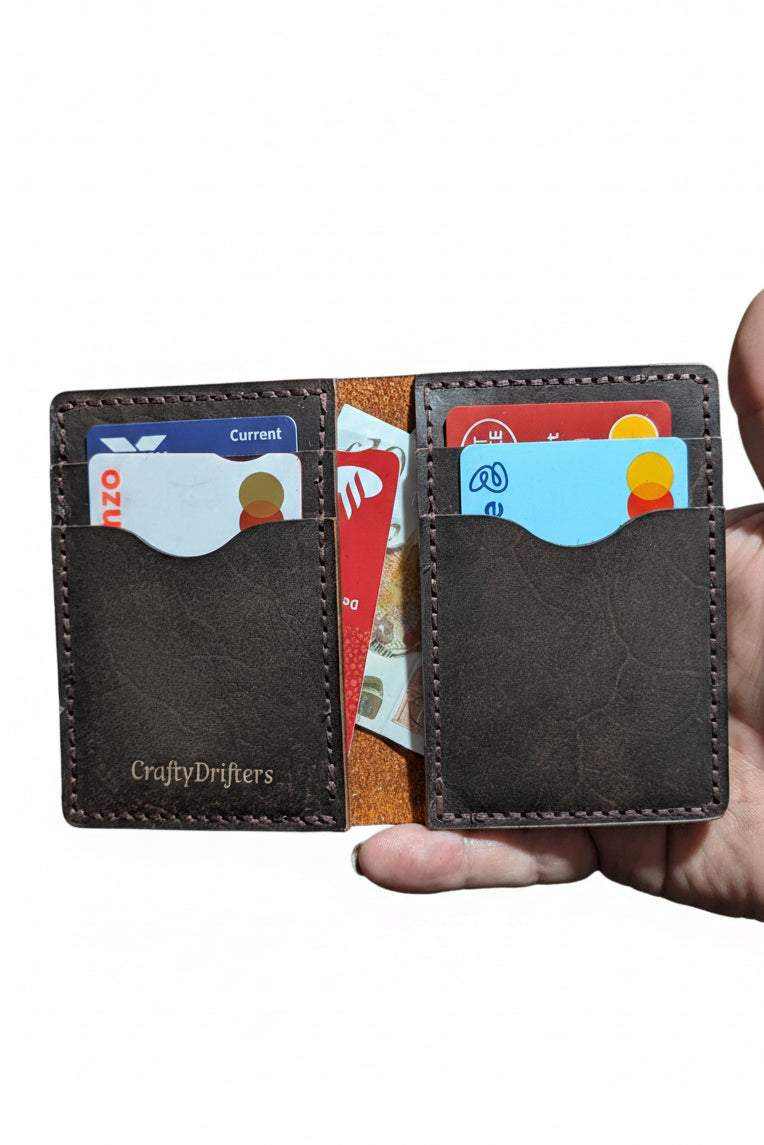 The Fistral dark brown leather bi-fold wallet open with bank cards inside
