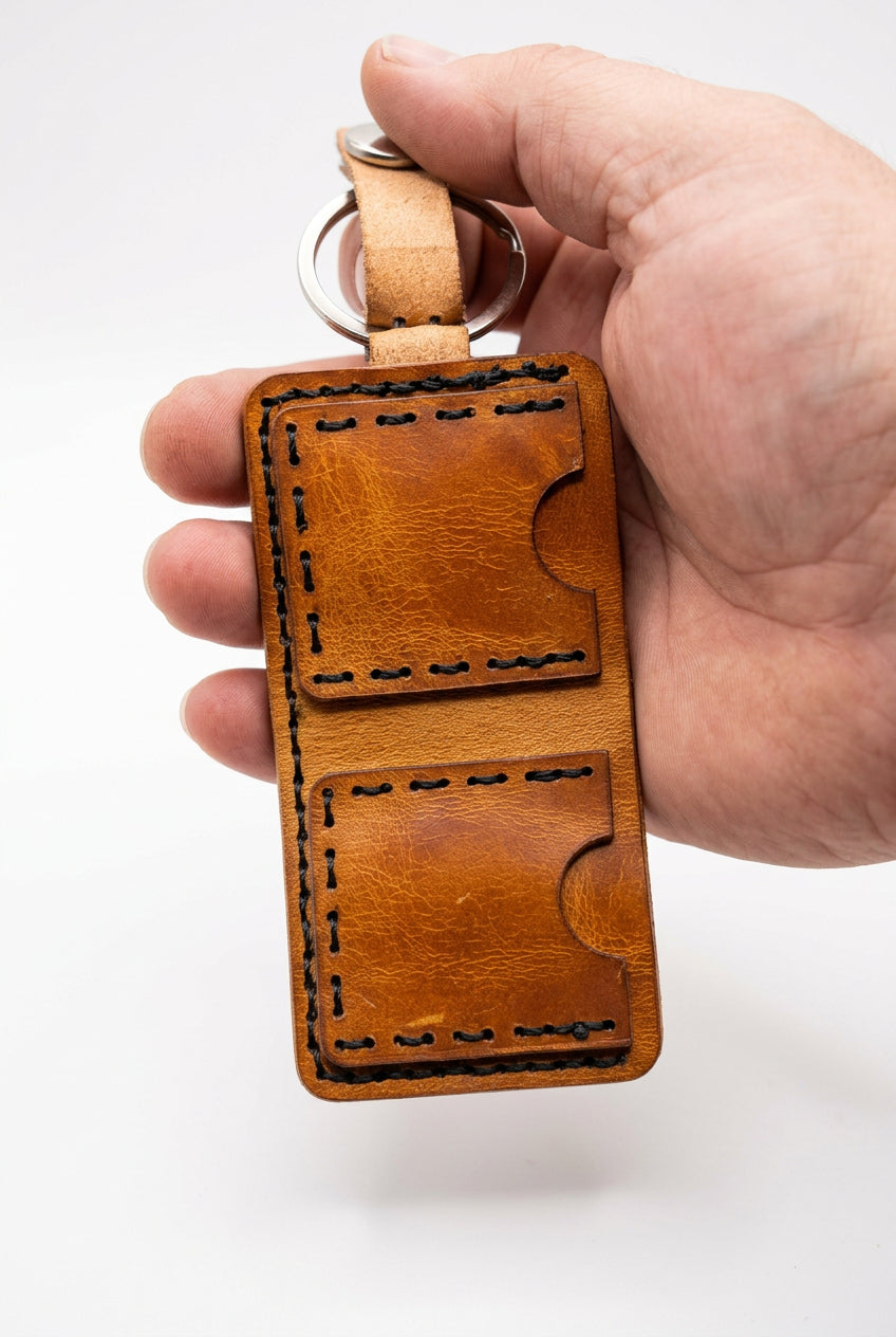 Tan KeyChain Micro Wallet open in hand, showing the two stitched pockets
