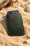 Green Badalassi Carlo leather card holder with a bank card, on sand