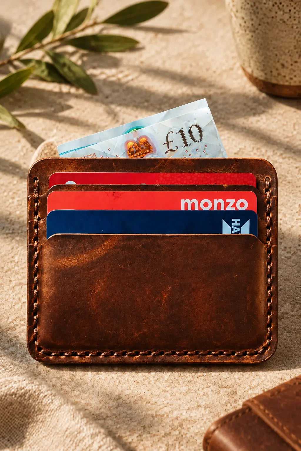 The Beast Badalassi leather card sleeve holding cards and a ten pound note