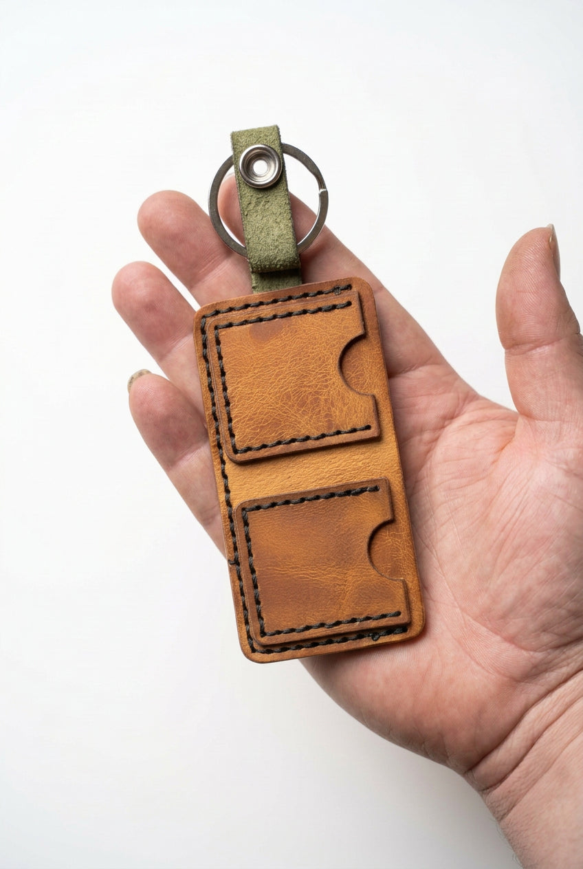 Tan KeyChain Micro Wallet with green leather tab and key ring, open in hand