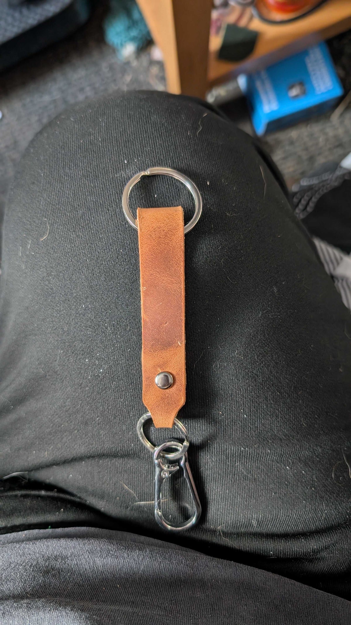 Tan leather strap keyring with clip, hooked onto a trouser belt loop