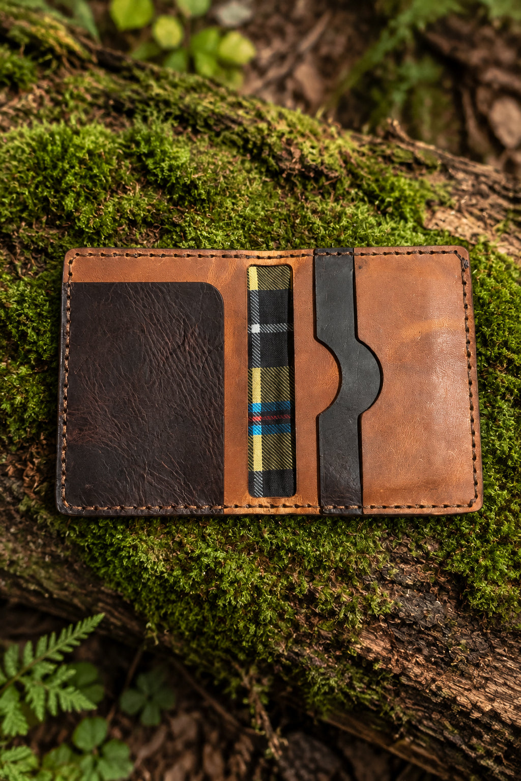 Badalassi leather bi-fold open on moss, dark and tan leather with Cornish tartan lining