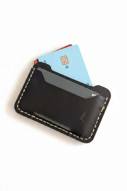 Handmade dark brown leather card holder with contrast stitching containing credit cards.
