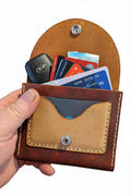 The Duporth handmade brown leather coin purse holding cards and a car key fob