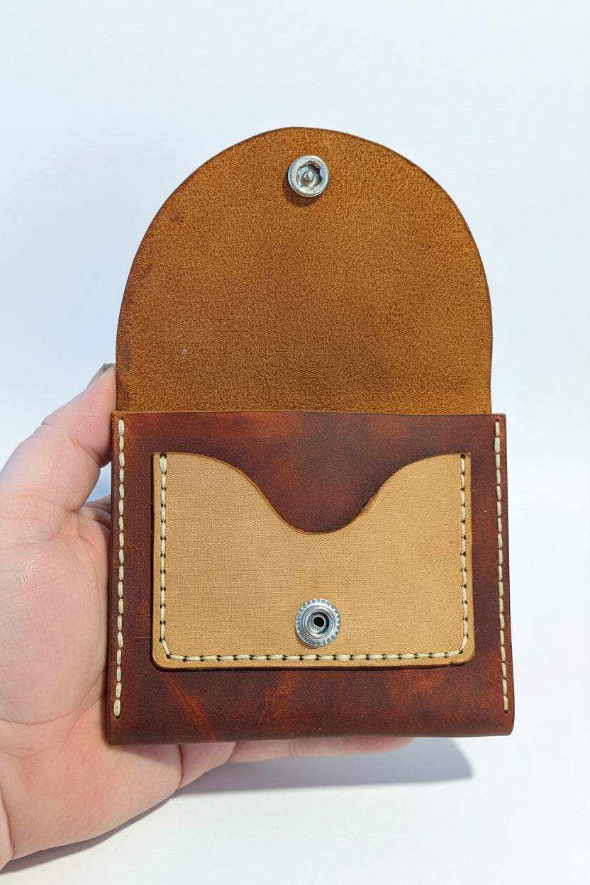 Handmade brown leather coin purse with snap closure and decorative stitching