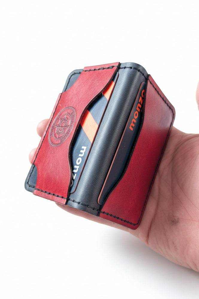 Handmade red leather card holder with black accents holding a Monzo bank card