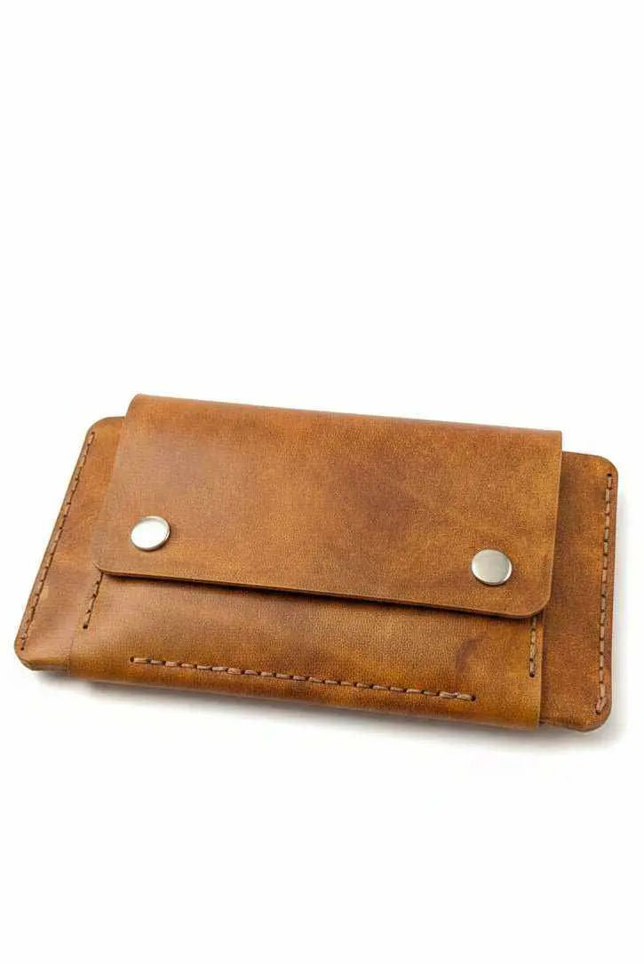 Handmade tan leather wallet with snap button closure and visible stitching.